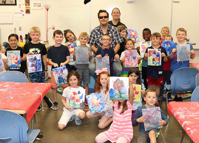 Students posing with their art and teacher