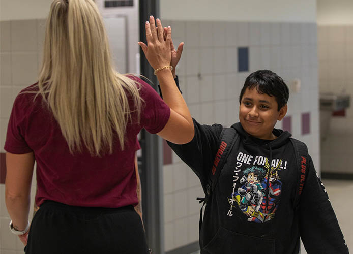 Students and staff high five 