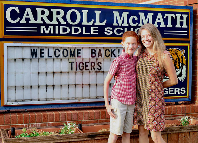 Student in front of a sign
